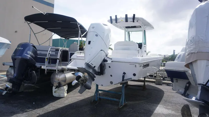 Slide: The Image of 2025 Everglades 253 CC boat with outboard motor in a marina. - 2