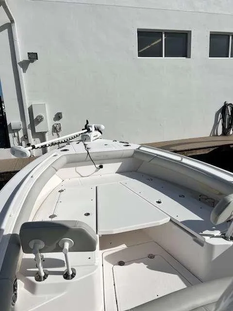 Slide: The Image of 2022 Everglades 273 CC boat deck, white interior, docked near a building. - 10