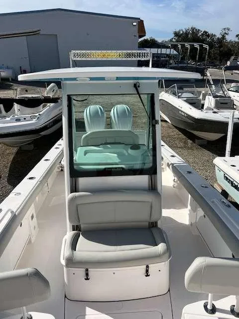 Slide: The Image of 2022 Everglades 273 CC boat with white seating and console, parked in a marina. - 11