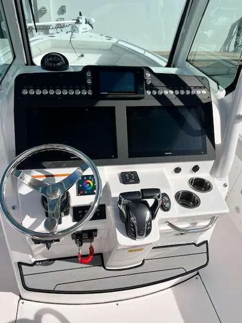 Slide: The Image of 2022 Everglades 273 CC boat dashboard with steering wheel and dual screens. - 6