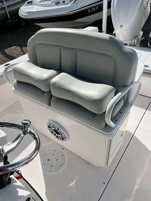 Slide: The Image of 2022 Everglades 273 CC boat seating with cushioned bench and steering wheel. - 7