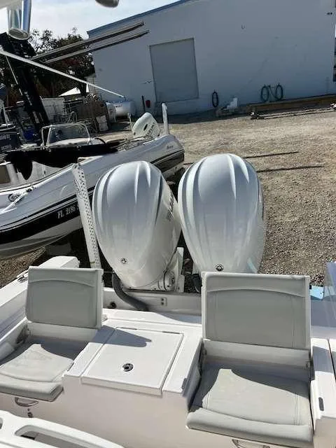 Slide: The Image of 2022 Everglades 273 CC boat with dual outboard engines in a marina setting. - 8