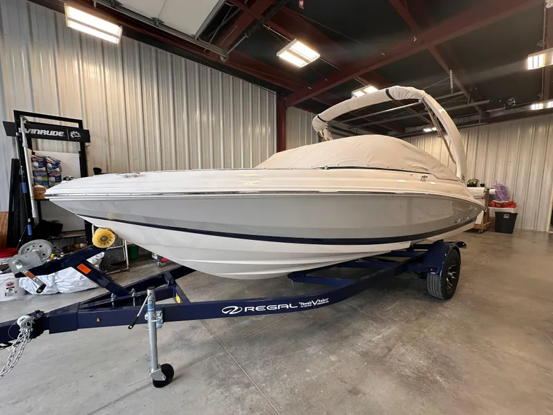 Slide: The Image of 2025 Regal 2000 ES boat in storage, covered and on a trailer. - 1