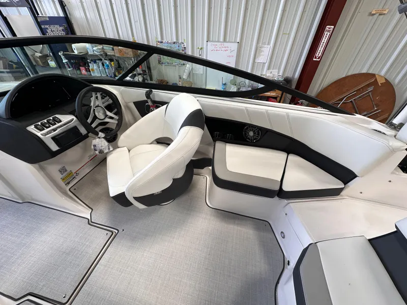 Slide: The Image of 2025 Regal 2000 ES boat interior with white seating and modern dashboard. - 11