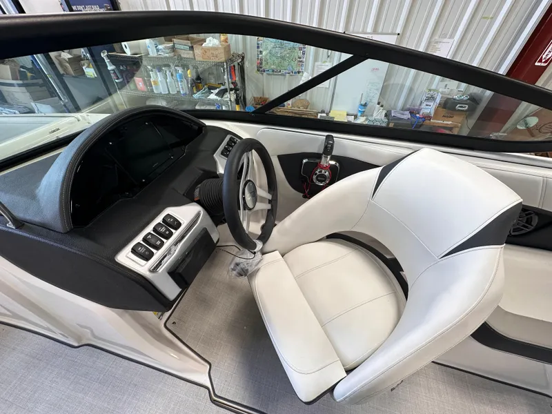 Slide: The Image of 2025 Regal 2000 ES boat interior with white leather seating and modern dashboard. - 12