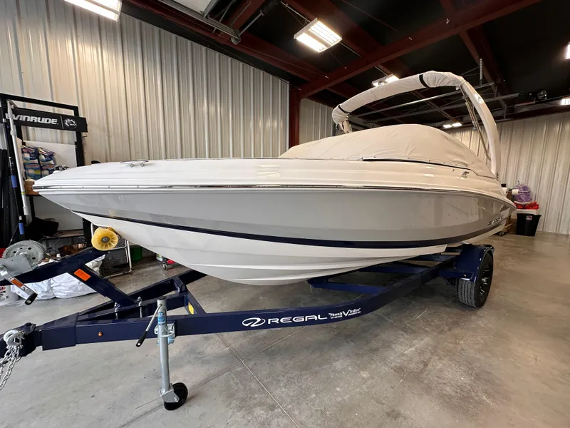 Slide: The Image of 2025 Regal 2000 ES boat on trailer in indoor storage facility. - 2