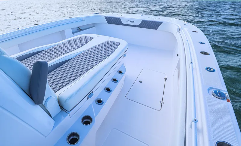 Slide: The Image of Invincible 35 Catamaran 2025, spacious deck with cushioned seating, on calm waters. - 10