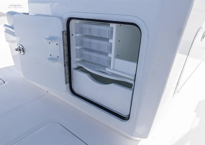 Slide: The Image of 2025 Invincible 35 Catamaran storage compartment with open door and organized shelves. - 30