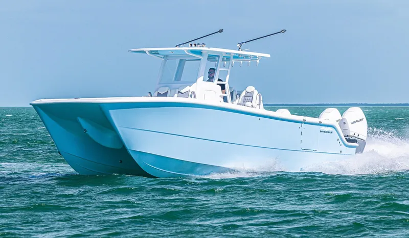 Slide: The Image of 2025 Invincible 35 Catamaran cruising on open water, showcasing sleek design and powerful engines. - 35