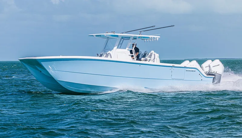 Slide: The Image of 2025 Invincible 35 Catamaran cruising on open water, showcasing sleek design and powerful engines. - 36