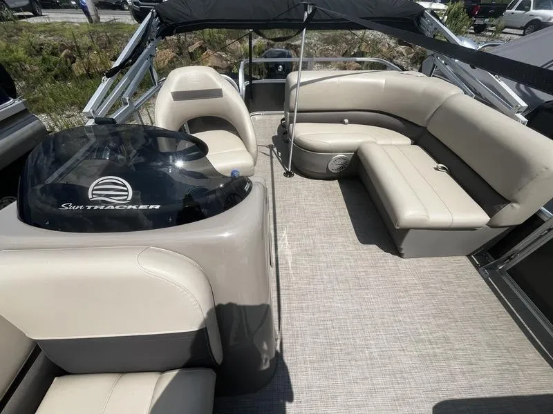 Slide: The Image of 2023 Sun Tracker Party Barge 18 interior with beige seating and helm. - 3