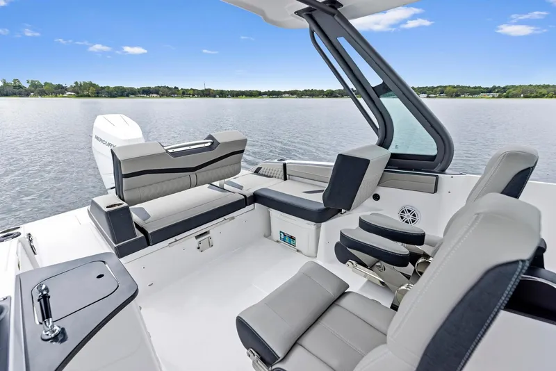 Slide: The Image of 2025 Monterey Elite 27 OB boat interior with sleek seating and modern design on a calm lake. - 6