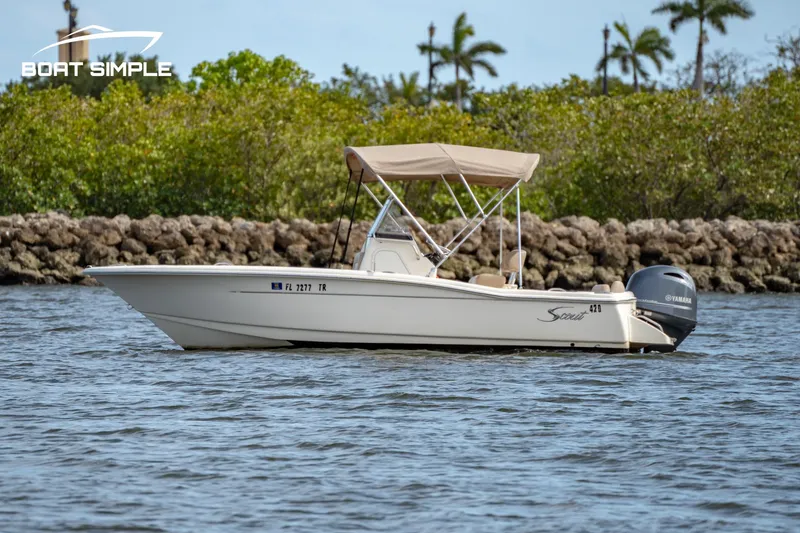 Slide: The Image of 2021 Scout 195 Sportfish boat on water with trees in background. - 3