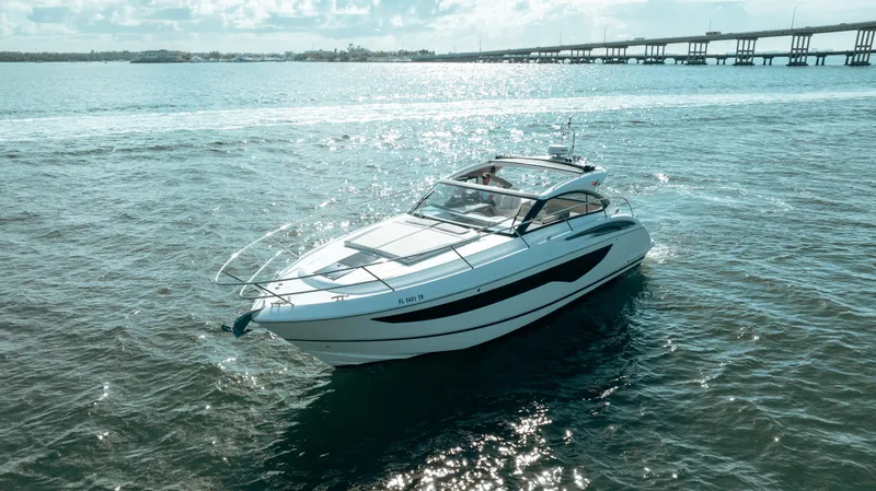 Slide: The Image of 2021 Princess V40 yacht cruising on open water near a bridge. - 7