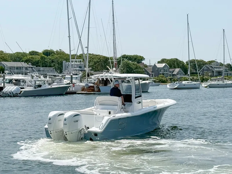 Slide: The Image of 2025 Sea Hunt Ultra 275 SE boat cruising in a marina with multiple sailboats. - 3