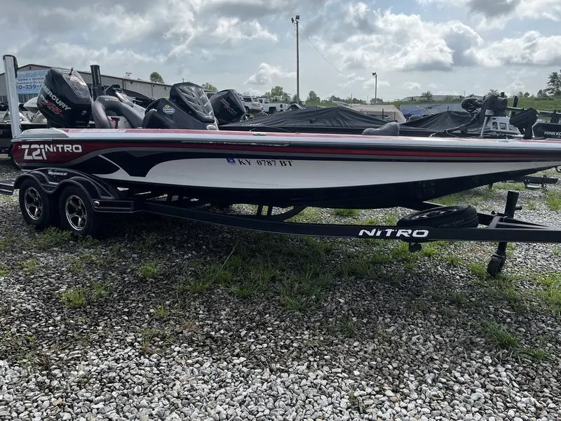 The Image of 2018 Nitro Z21 boat on trailer, parked on gravel lot under cloudy sky. - 1