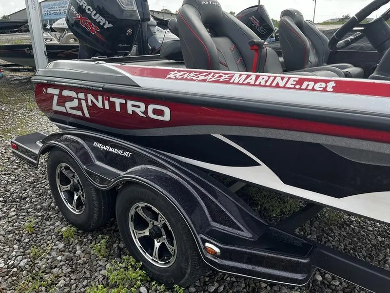 Slide: The Image of 2018 Nitro Z21 boat with dual axle trailer on gravel surface. - 3