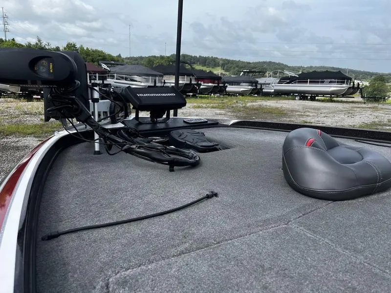 Slide: The Image of 2018 Nitro Z21 boat deck with fishing equipment and seat, parked near other boats. - 7
