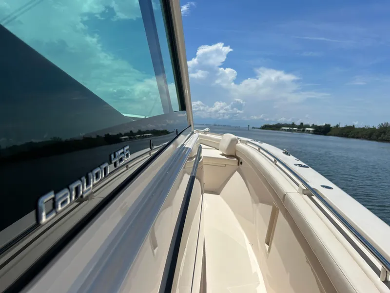 Slide: The Image of 2024 Grady-White Canyon 456 boat on calm water under blue sky. - 18
