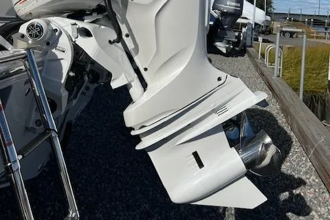 Slide: The Image of Close-up of 2025 Cobia 265 Center Console Open boat engine on gravel surface. - 21