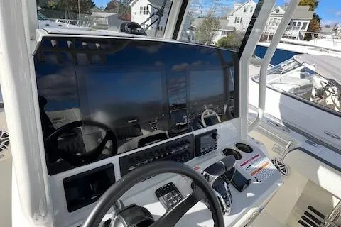Slide: The Image of 2025 Cobia 265 Center Console Open boat dashboard with steering wheel and controls. - 4