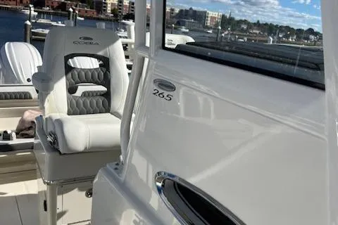 Slide: The Image of 2025 Cobia 265 Center Console Open boat interior with seating and dock view. - 7