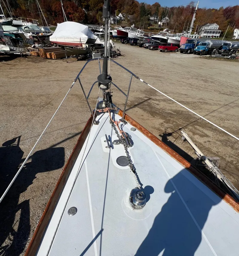 Slide: The Image of 1967 Hinckley Bermuda sailboat deck with anchor chain, docked in a boatyard. - 13
