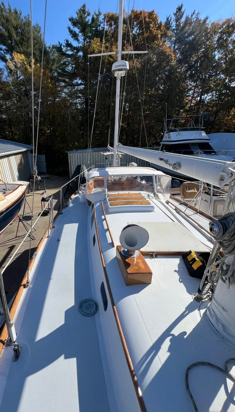 Slide: The Image of 1967 Hinckley Bermuda sailboat deck with mast, surrounded by trees and boats. - 16