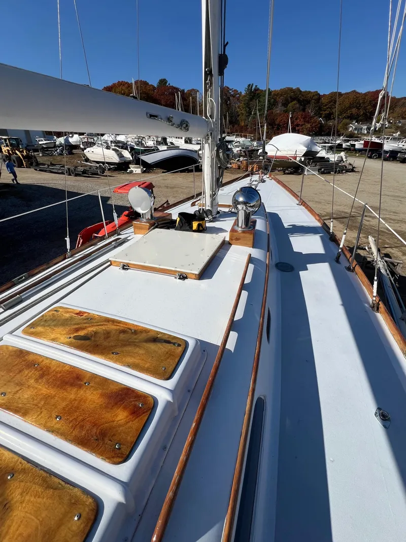 Slide: The Image of 1967 Hinckley Bermuda sailboat deck with wooden accents, docked in a marina. - 17