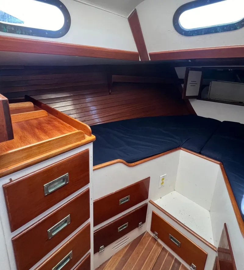 Slide: The Image of 1967 Hinckley Bermuda yacht interior with wood paneling and storage drawers. - 32