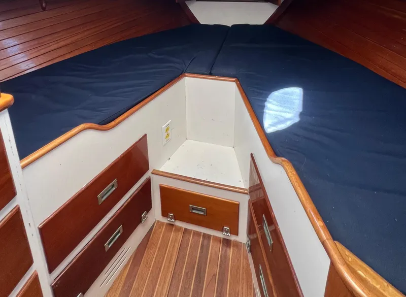 Slide: The Image of 1967 Hinckley Bermuda cabin interior with wooden drawers and blue cushions. - 34