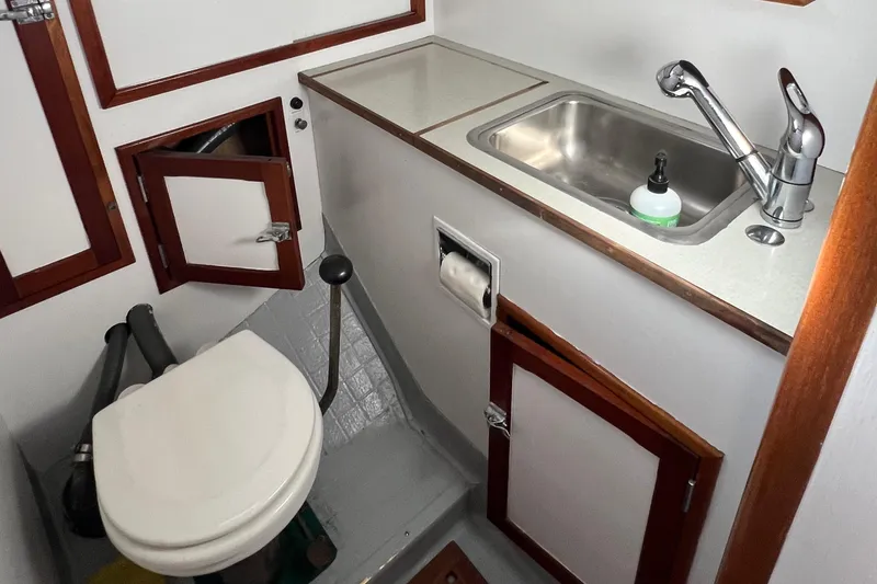 Slide: The Image of 1967 Hinckley Bermuda yacht bathroom with sink, toilet, and wooden cabinetry. - 37