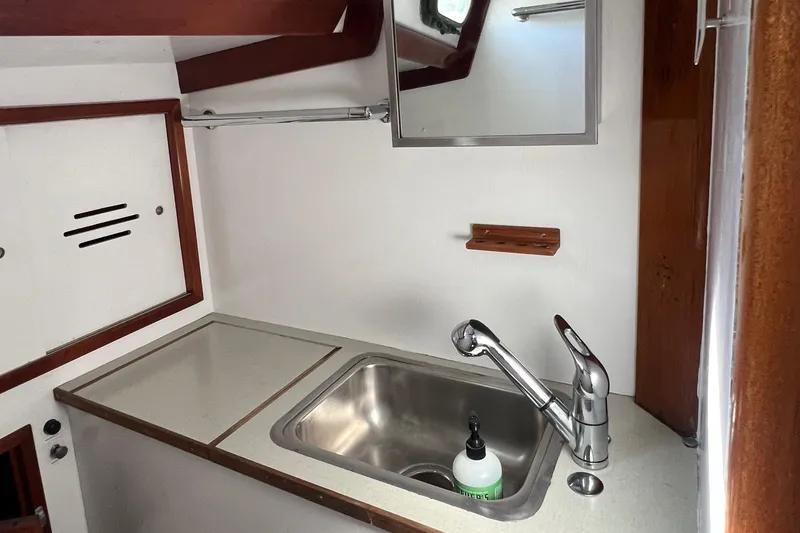 Slide: The Image of 1967 Hinckley Bermuda yacht interior with sink and mirror in compact galley area. - 38