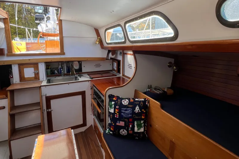 Slide: The Image of Interior of a 1967 Hinckley Bermuda sailboat, featuring a cozy cabin with wooden finishes. - 39