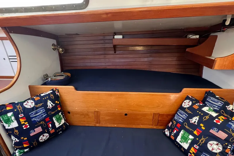 Slide: The Image of 1967 Hinckley Bermuda yacht cabin with wooden interior and nautical-themed cushions. - 43