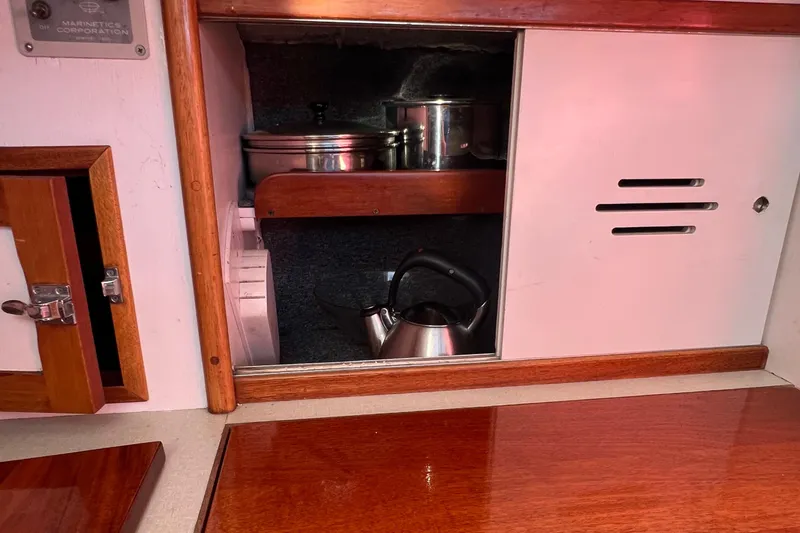 Slide: The Image of 1967 Hinckley Bermuda yacht interior with wooden cabinetry and kitchenware. - 47