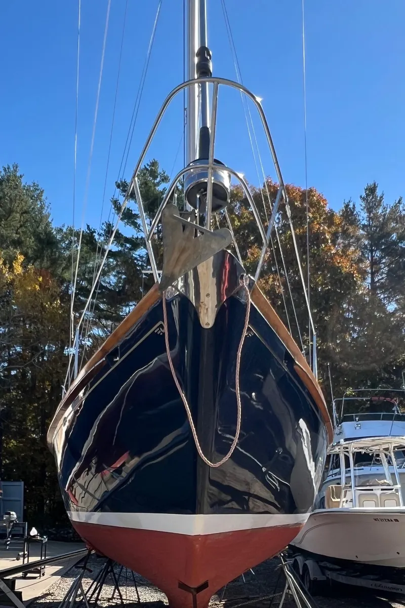 Slide: The Image of 1967 Hinckley Bermuda sailboat with a sleek hull, docked outdoors. - 5
