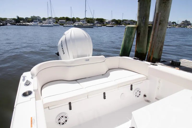 Slide: The Image of 2025 Sea Hunt Ultra 245 SE boat with Yamaha engine docked by the water. - 2