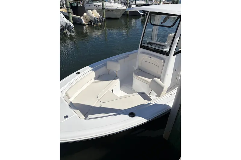 Slide: The Image of 2025 Sea Hunt Ultra 245 SE boat with spacious seating at a marina. - 5