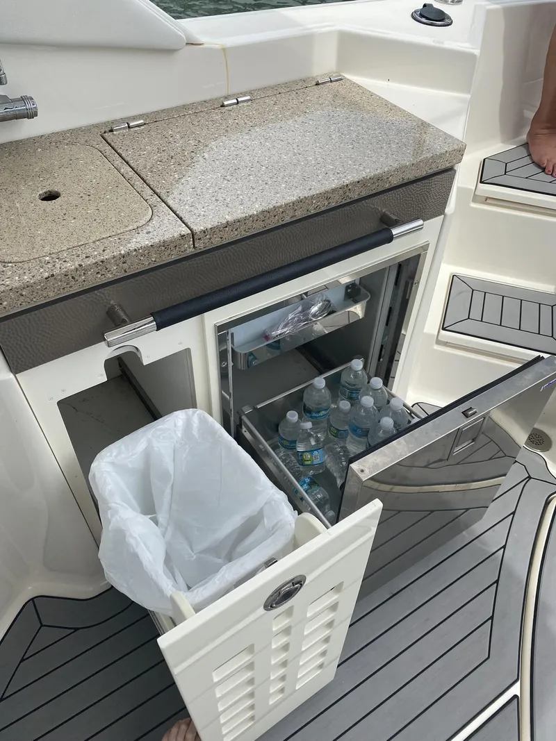 Slide: The Image of 2016 Sea Ray 350 SLX boat with mini fridge and trash bin on deck. - 17