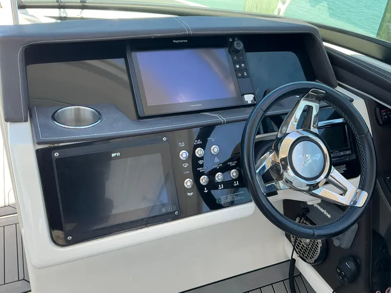 Slide: The Image of 2016 Sea Ray 350 SLX dashboard with steering wheel and navigation screens. - 34