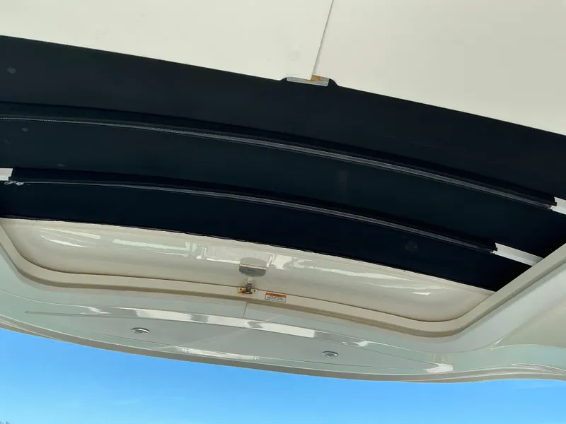 Slide: The Image of 2016 Sea Ray 350 SLX boat sunroof interior view against blue sky. - 43