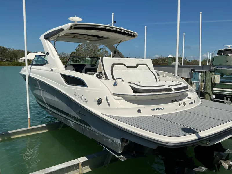 Slide: The Image of 2016 Sea Ray 350 SLX boat docked on a sunny day, showcasing sleek design and luxury features. - 44