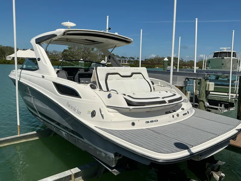 Slide: The Image of 2016 Sea Ray 350 SLX boat docked in a marina under clear blue skies. - 45