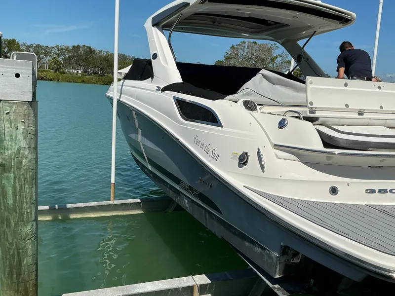 Slide: The Image of 2016 Sea Ray 350 SLX boat docked on a lift in a serene waterway. - 47