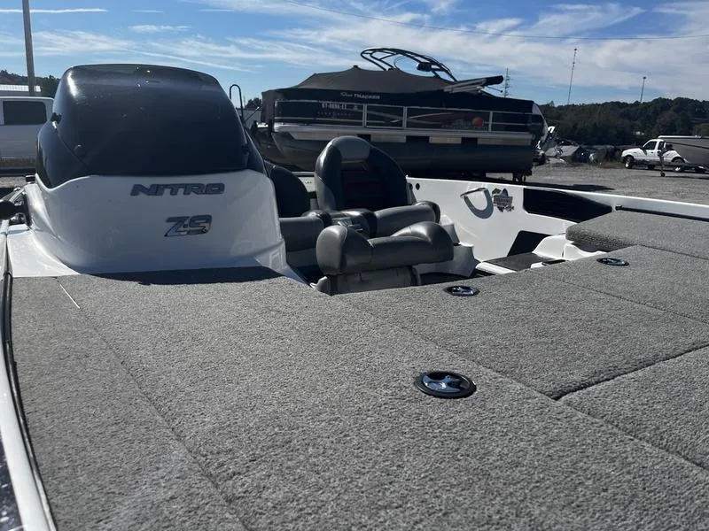 Slide: The Image of 2011 Nitro Z9 boat with cushioned seating and spacious deck in a marina setting. - 6