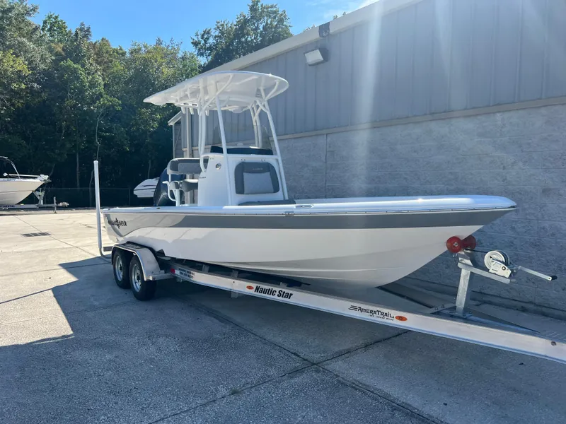 Slide: The Image of 2025 NauticStar 224 Bay boat on trailer, parked outdoors. - 23