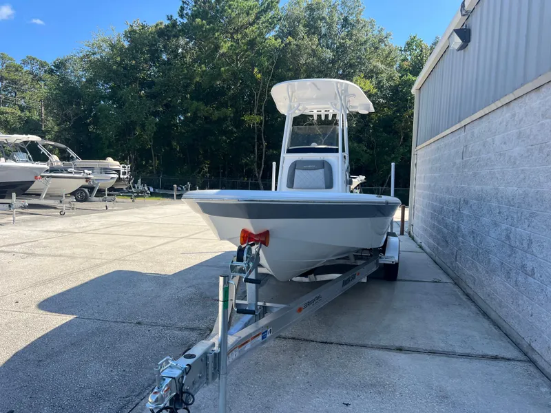 Slide: The Image of 2025 NauticStar 224 Bay boat on trailer, parked outdoors near a building. - 25