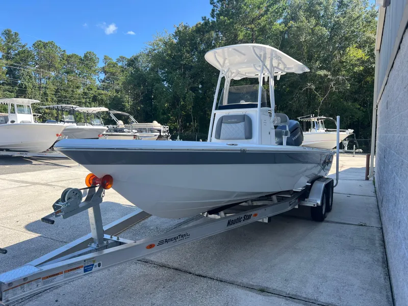Slide: The Image of 2025 NauticStar 224 Bay boat on trailer, parked outdoors. - 26