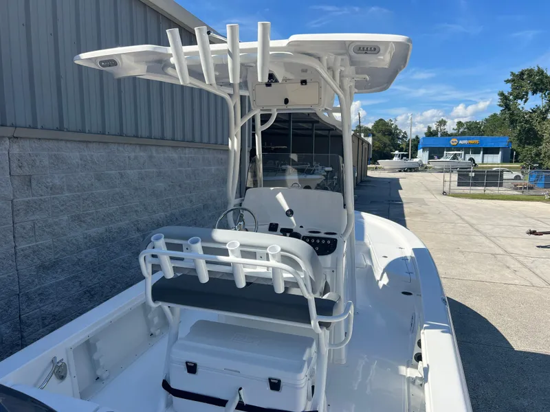 Slide: The Image of 2025 NauticStar 224 Bay boat with T-top, docked outdoors under clear blue sky. - 28